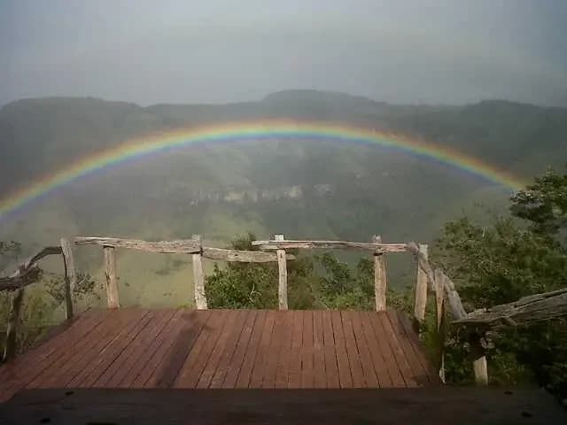 A rainbow appearing through mist over the valley