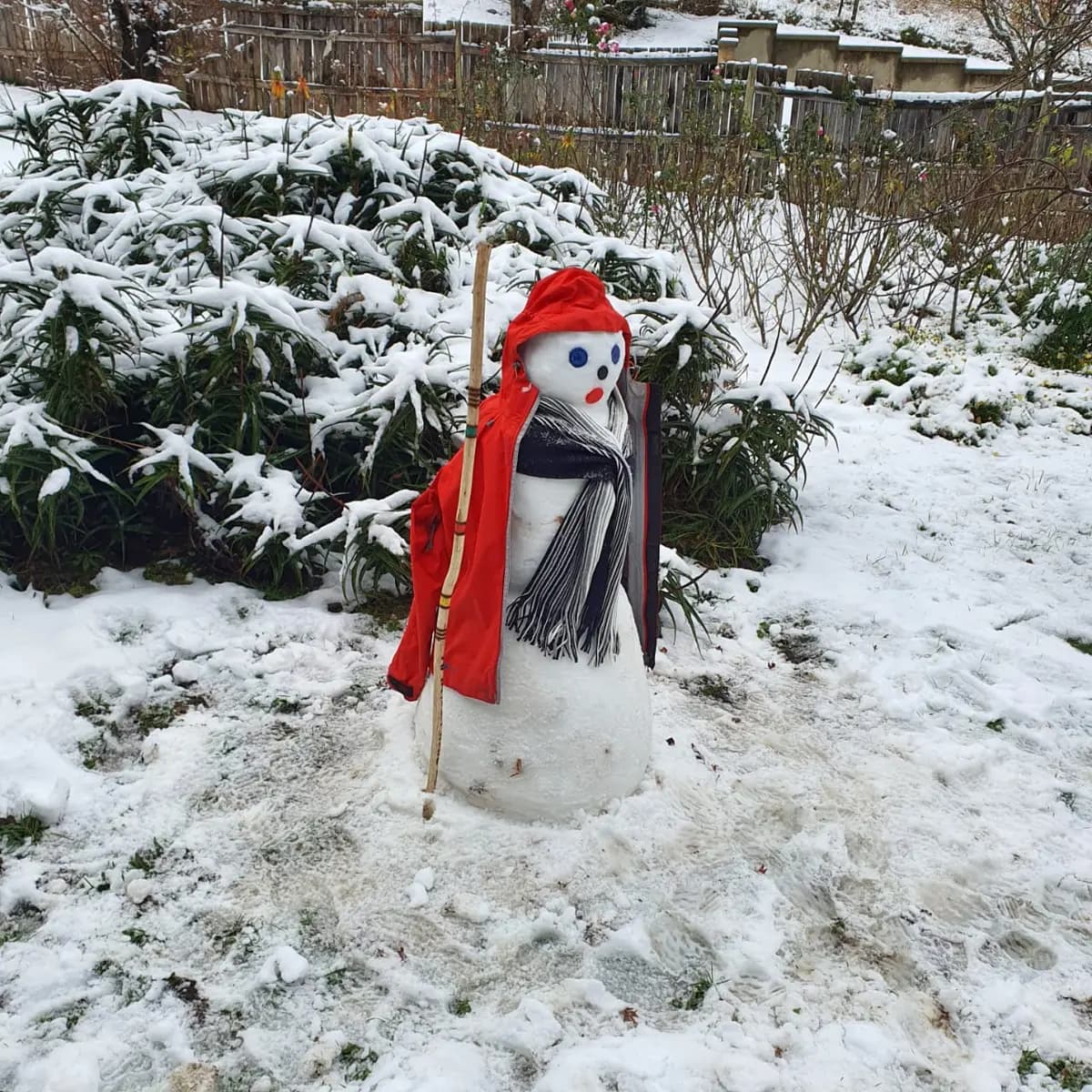 A small snowman in a red coat in a Hogsback garden